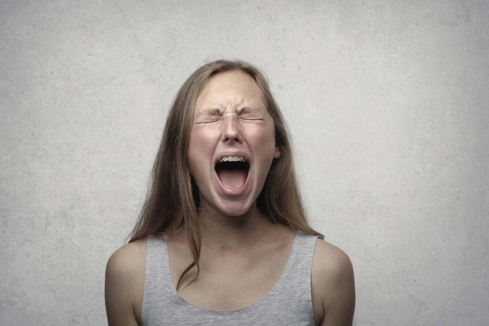 Woman in Gray Tank Top screaming in anger