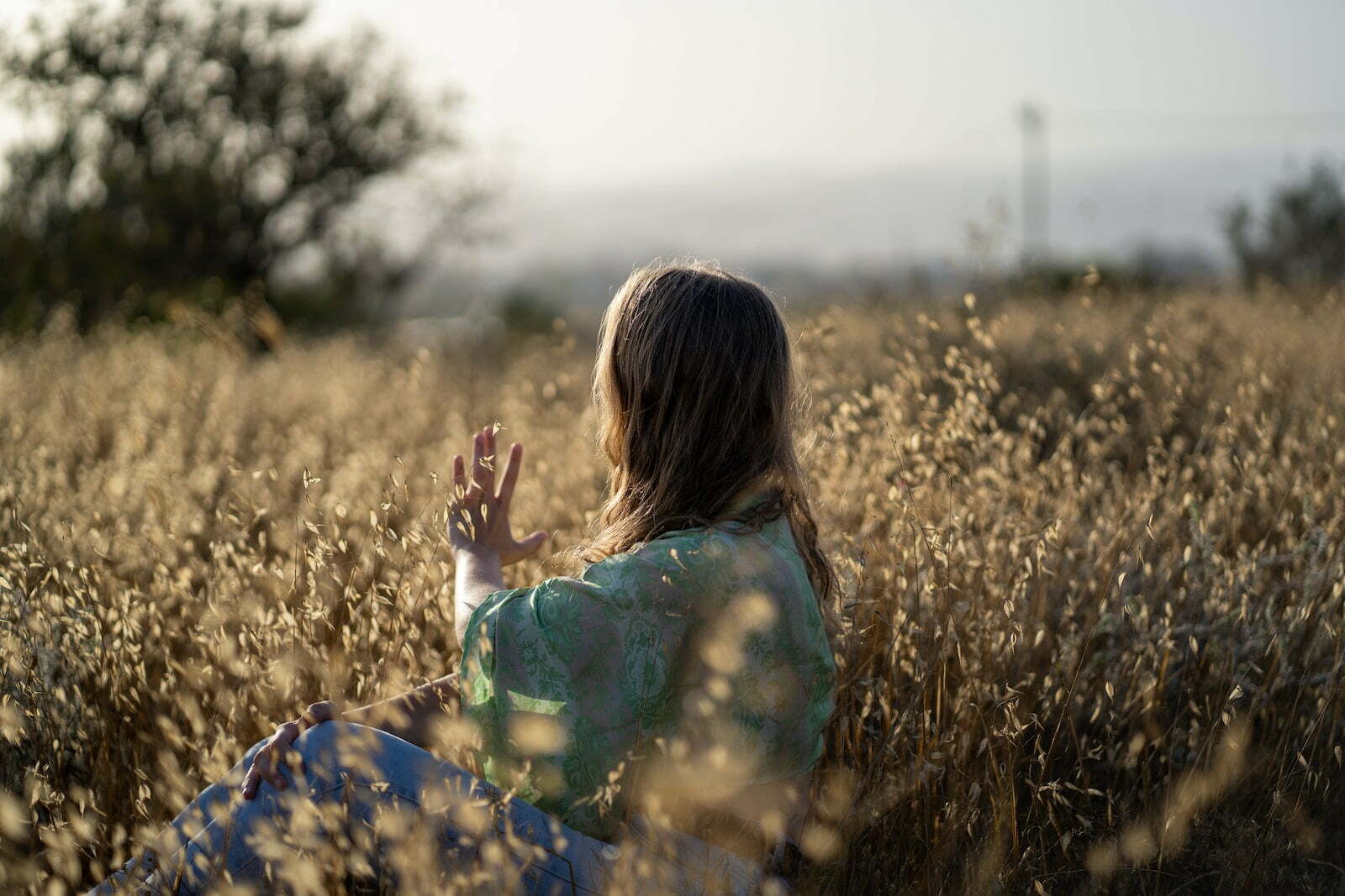 woman in blue and green floral dress standing on brown grass field during daytime