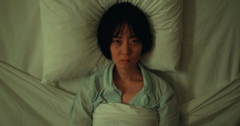 Woman lying awake in bed staring at the ceiling