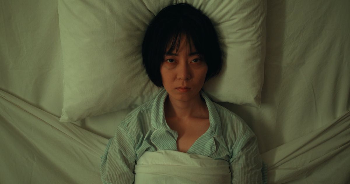 Woman lying awake in bed staring at the ceiling