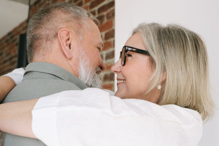 A couple in their sixties holding each other and smiling